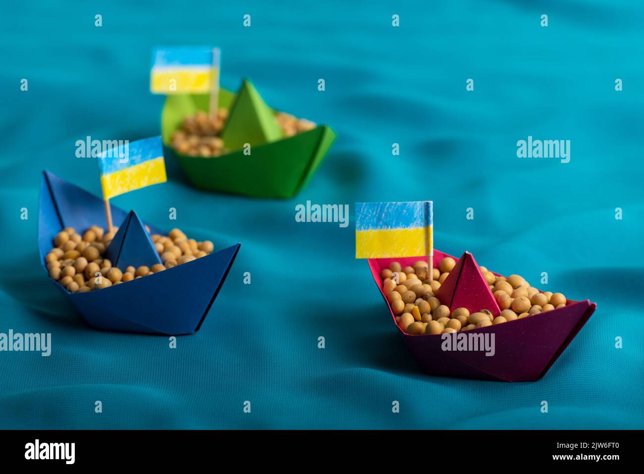 Boats with Ukrainian soybeans made of paper origami concept Stock Photo