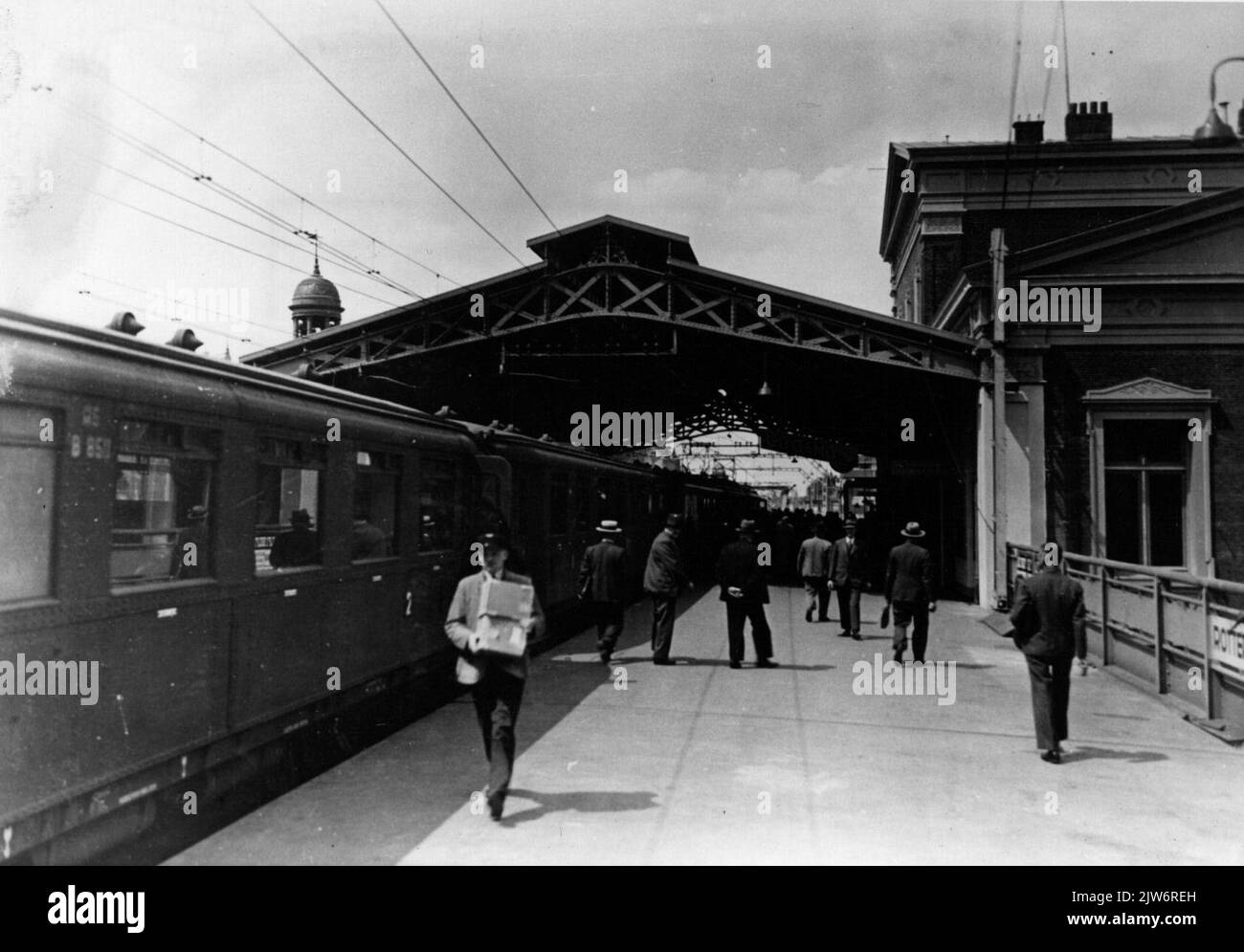 View of the platform with platform hood of the N.S. station Rotterdam Beurs in Rotterdam with a train consisting of carriages of electric buffer equipment (Mat. 1924, 'block boxes') of the N.S.N.B. The name Rotterdam Beurs was later changed to Rotterdam Blaak. Stock Photo