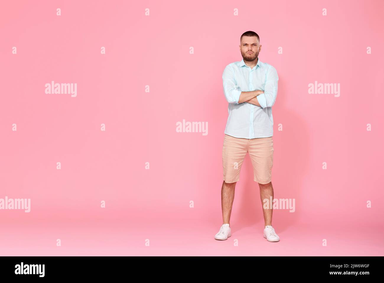 young caucasian man holding hands crossed looking camera Stock Photo