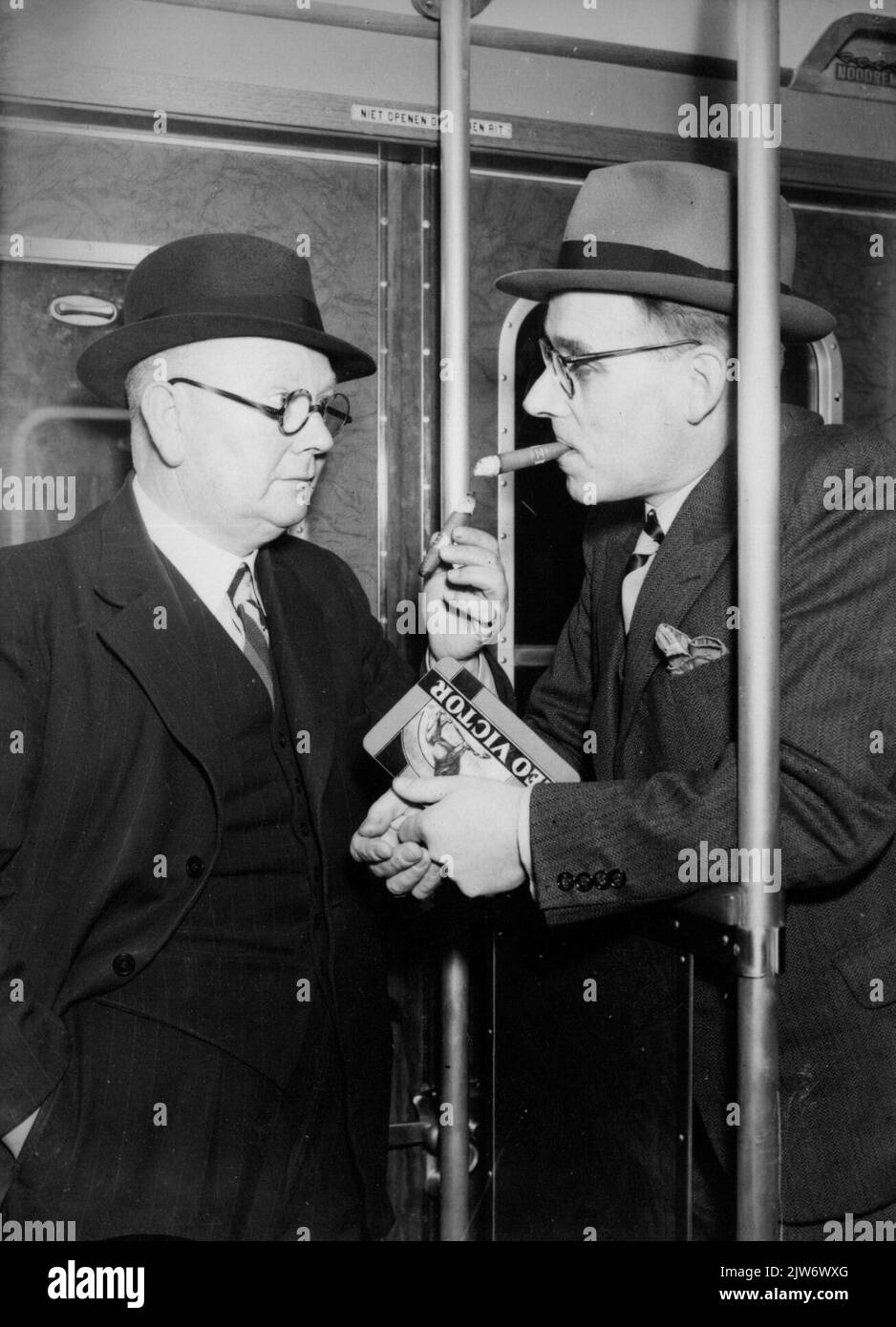 Image of two cigars smoking men on the balcony of a train (publicity photo). Stock Photo