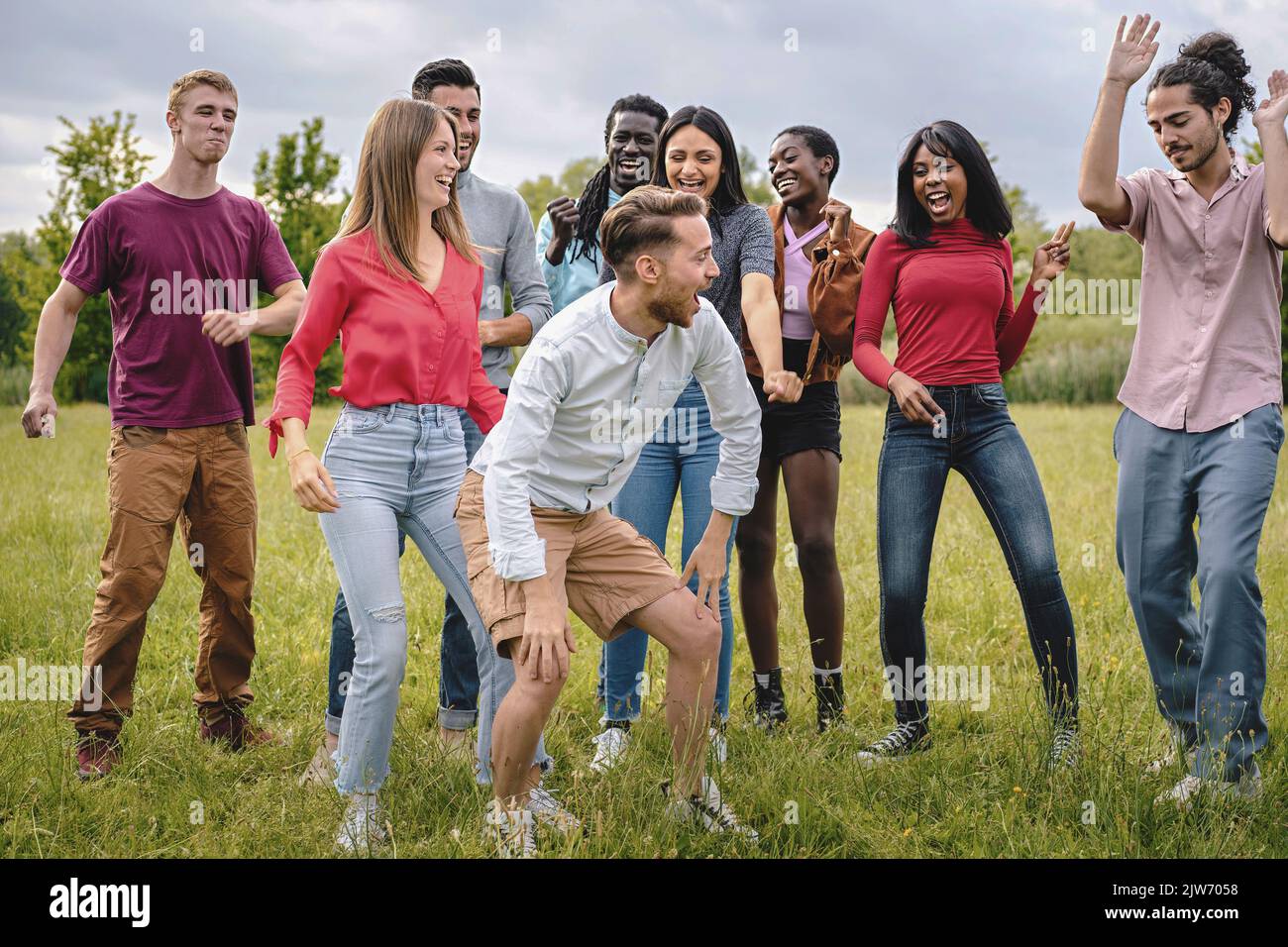 Cheerful multiracial group happy young people having fun dancing together playing together smiling and bonding together - multiethnic friends gatherin Stock Photo