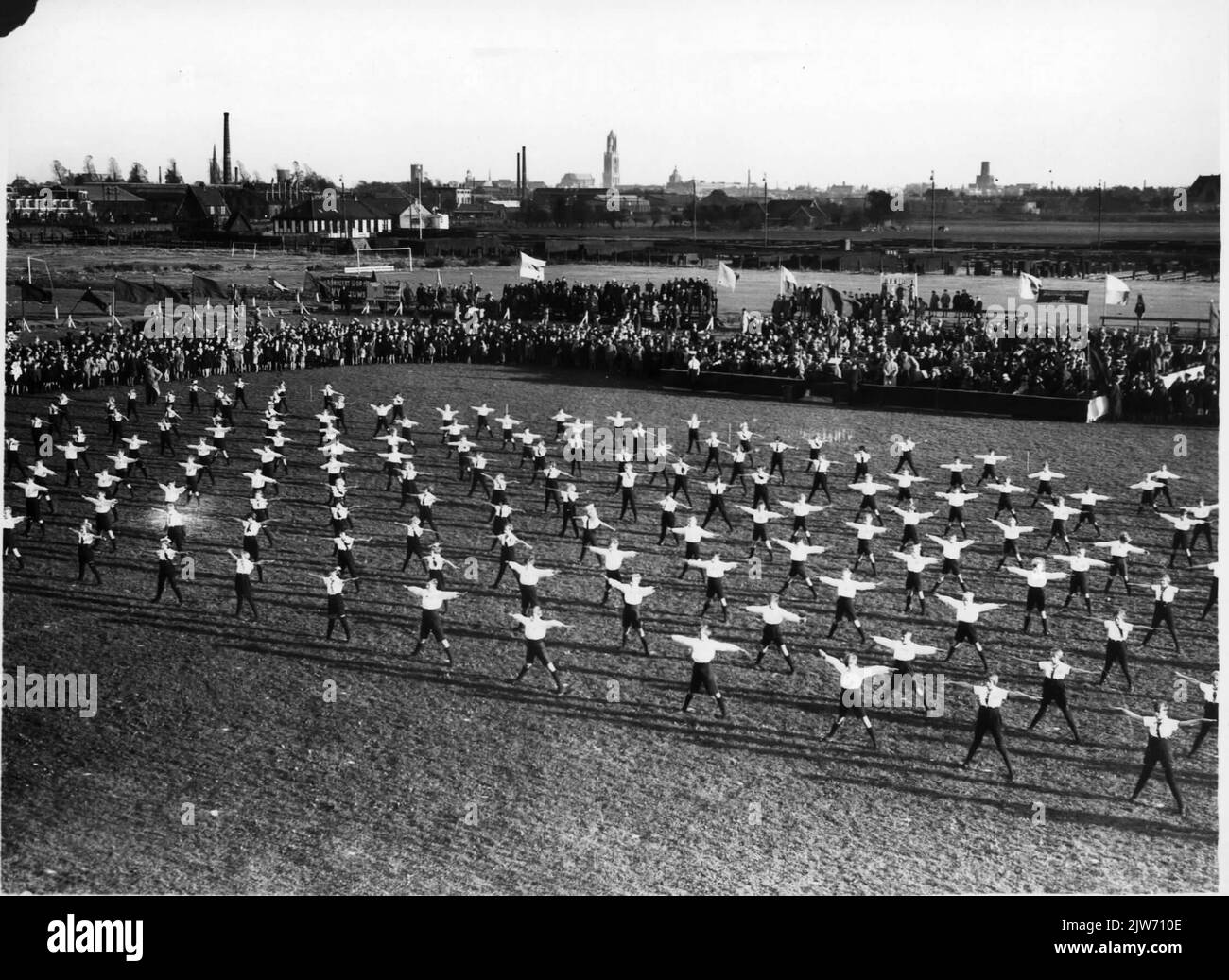 Image of a sports demonstration of members of workers' sports associations on the U.V.V. site on the Lageweidschedijk in Utrecht during the celebration of the silver jubilee of the General Cooperative Production and Consumer Association Voorwaarts on Oct. 25. 1931. In the background the stacking site of the Dutch Railways. Stock Photo