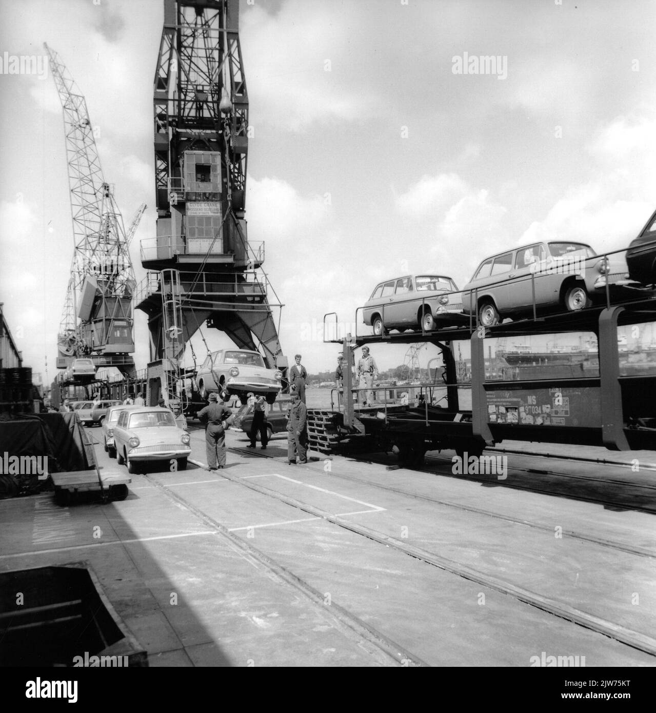 Image of overloading passenger cars (Ford Anglias) from a ship to train