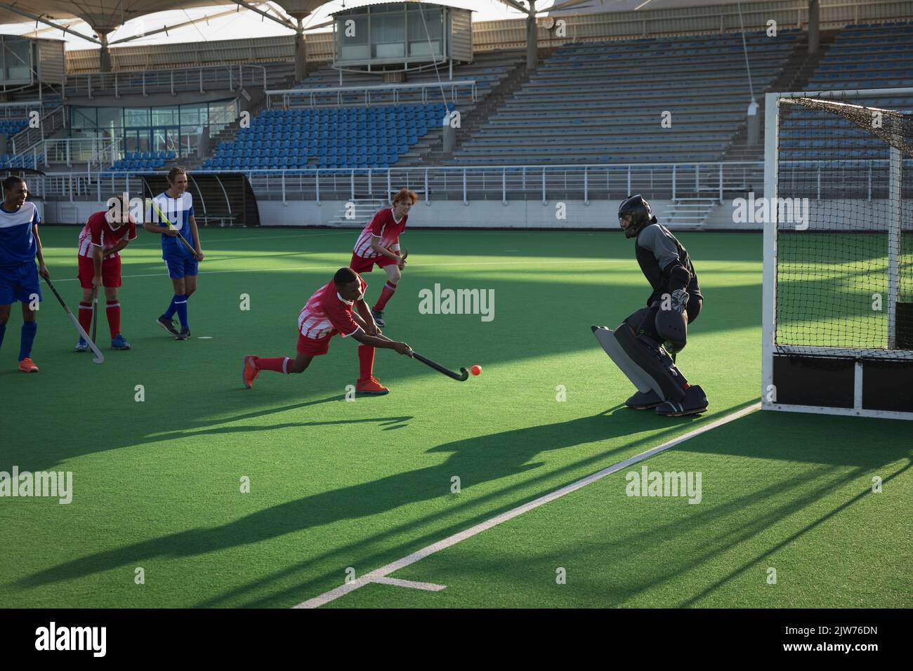 Field hockey player taking a shot a goal during a match Stock Photo