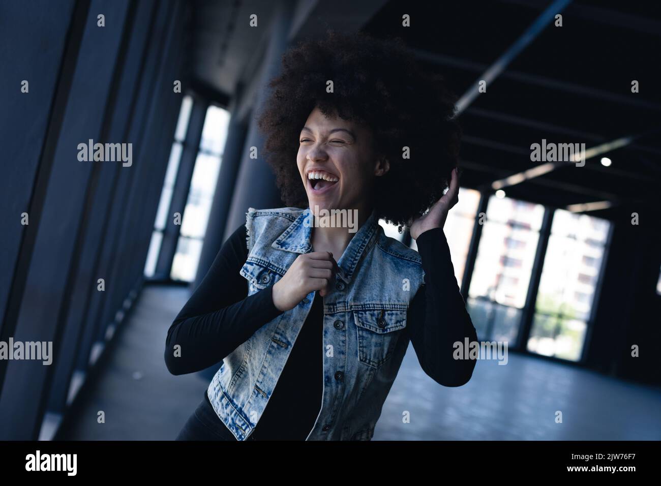 Mixed race woman laughing and dancing in an empty building Stock Photo ...