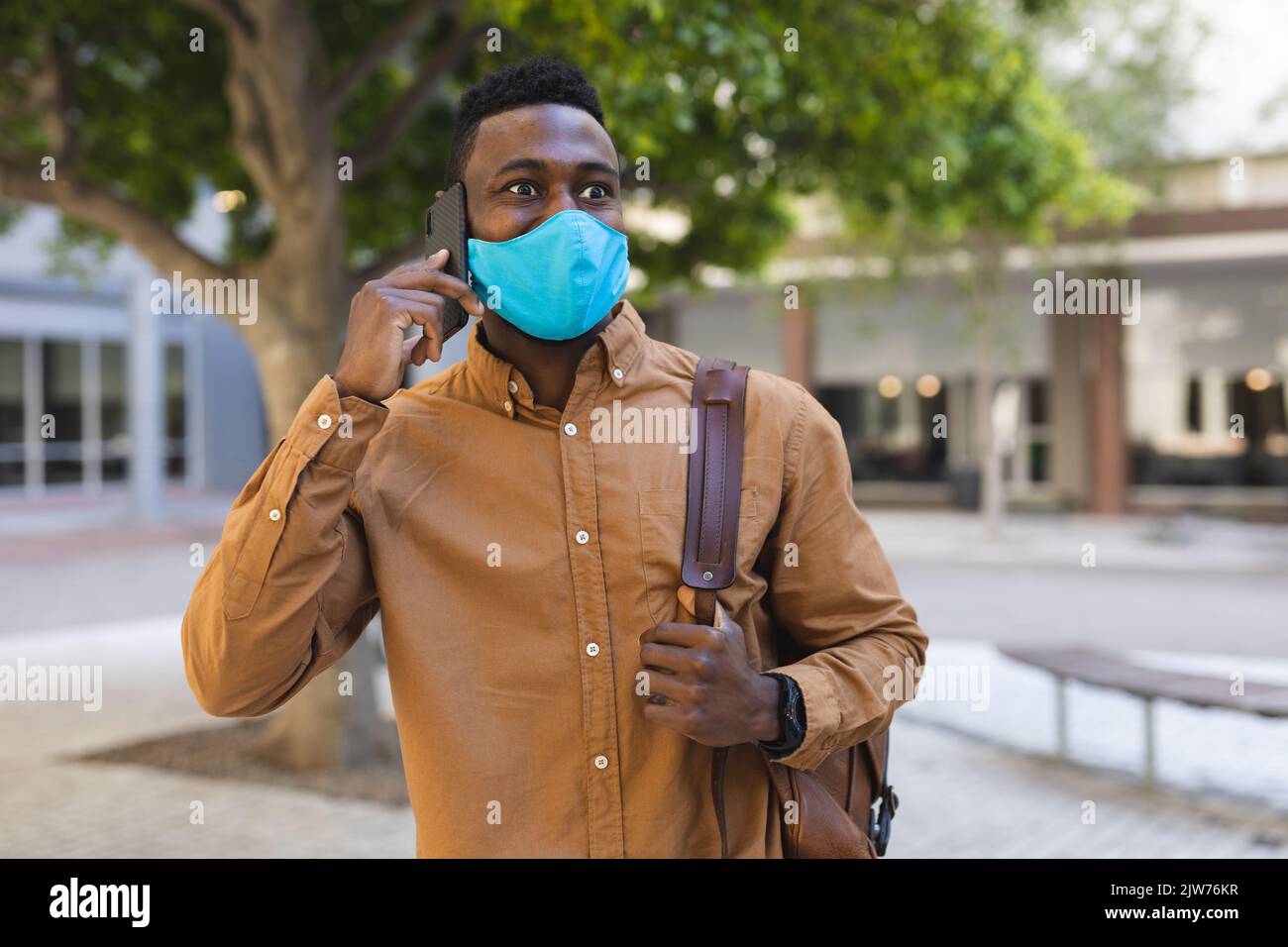 African american man walking talking on a smartphone Stock Photo