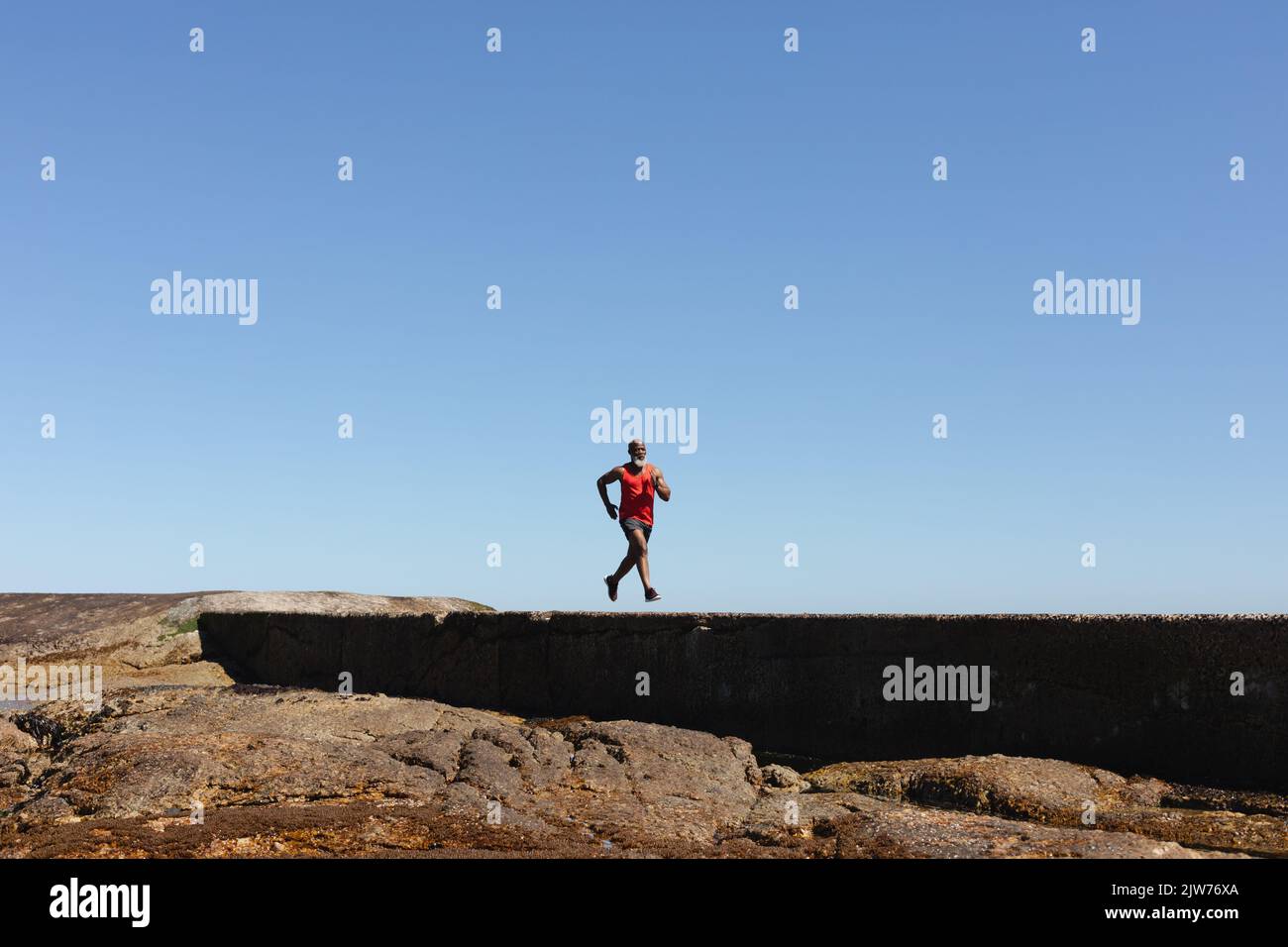 Fit Senior African American Man Exercising Running On Coastal Path