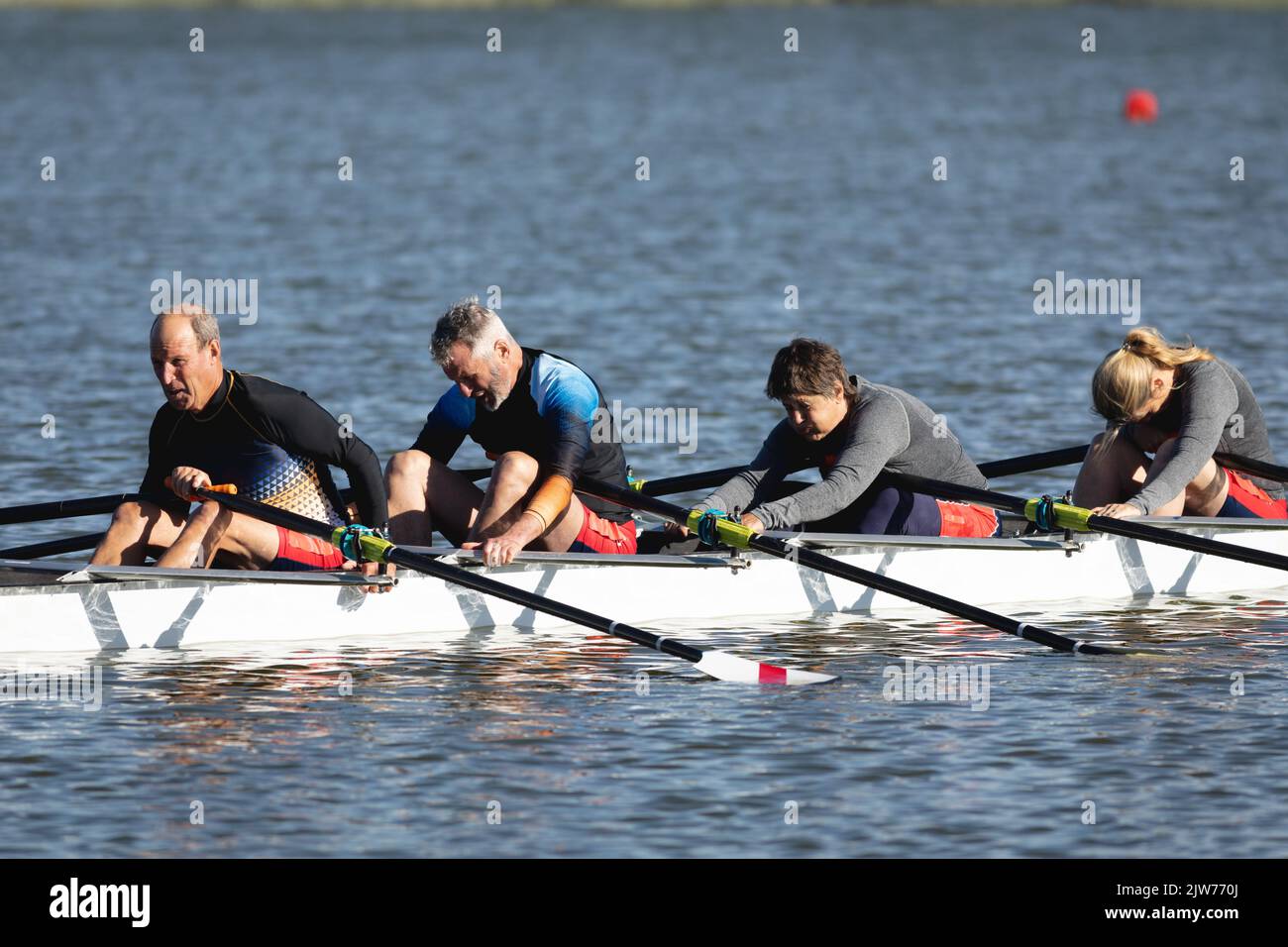 Tired senior caucasian rowing team taking a break from rowing the boat ...