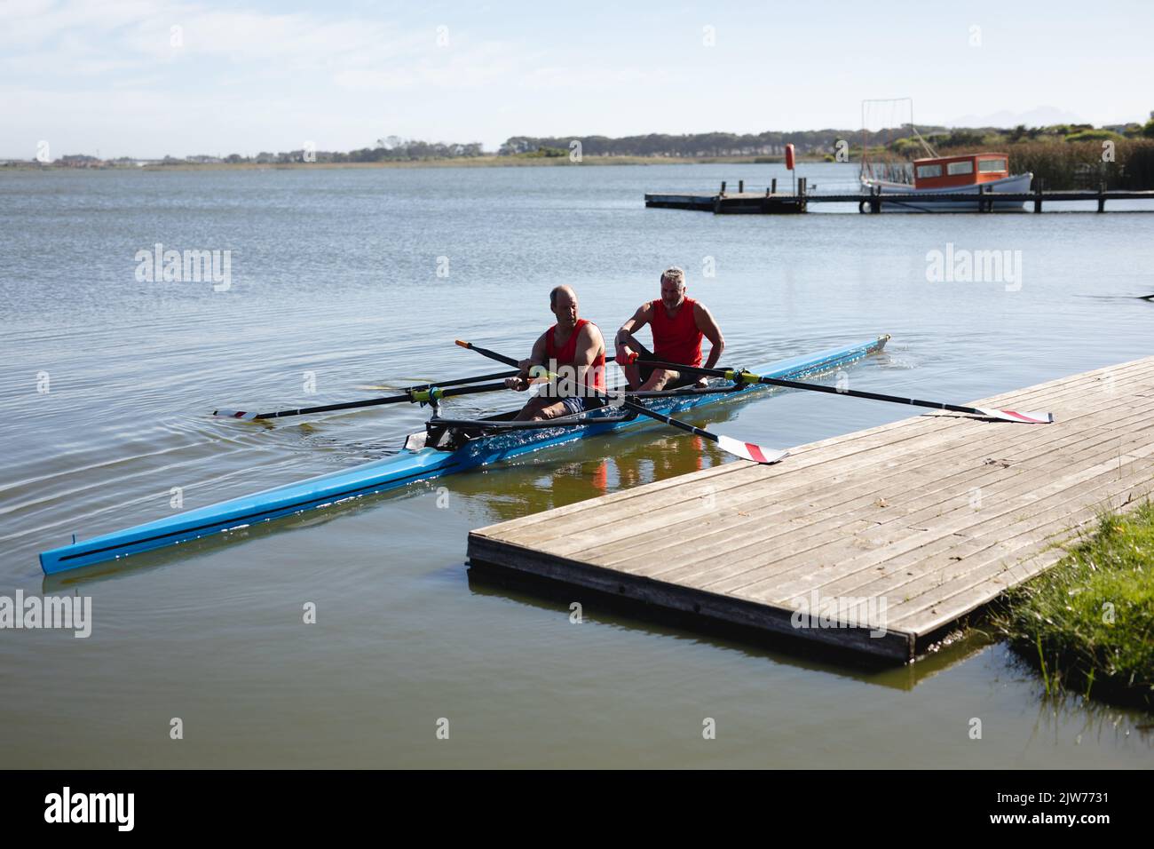 Two senior caucasian male rowers rowing the boat on the lake Stock
