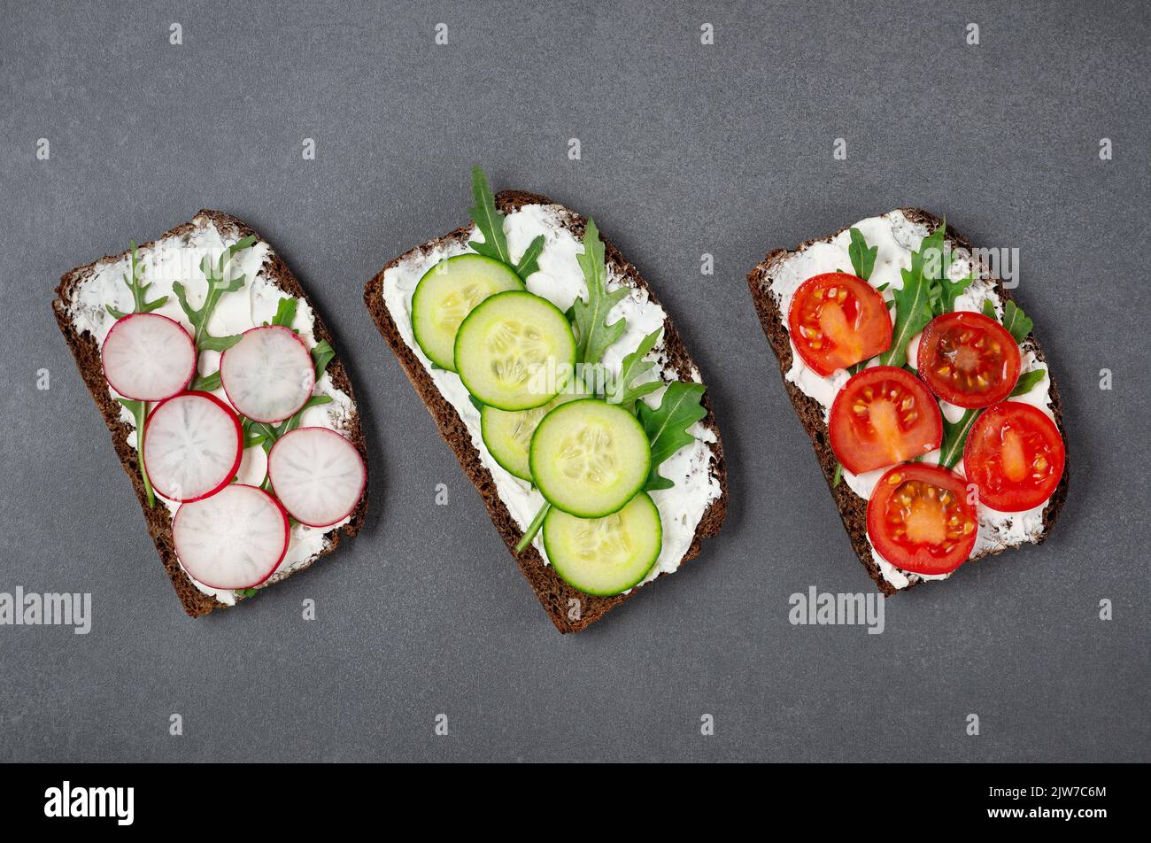 Healthy sandwiches with white cottage cheese, cucumber, arugula, tomato