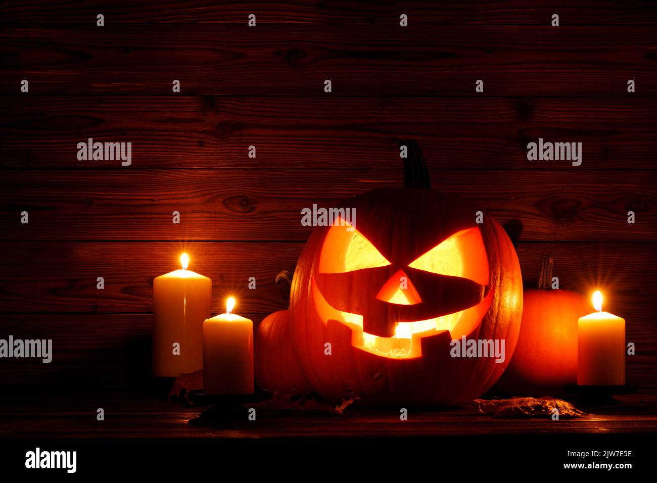 Halloween night glowing pumpkins and candles on wooden background Stock Photo