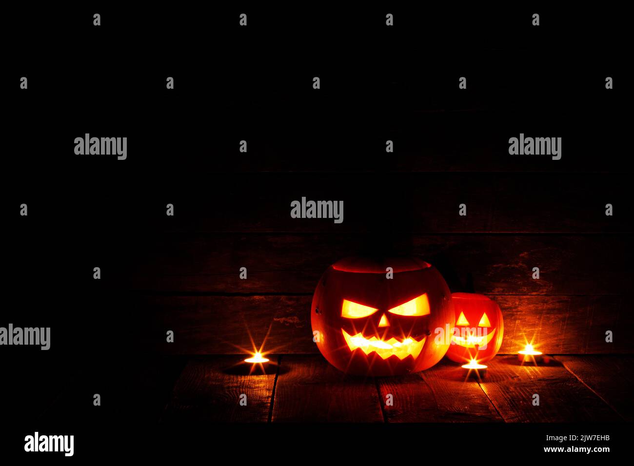 Halloween Jack O Lantern pumpkins and burning candles traditional decoration Stock Photo