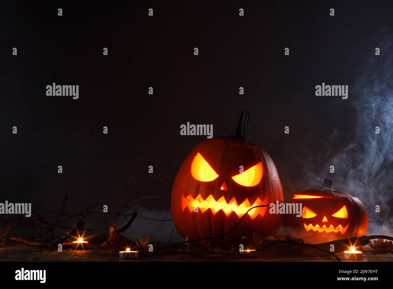 Halloween Jack O Lantern pumpkins and burning candles in mist traditional decoration Stock Photo
