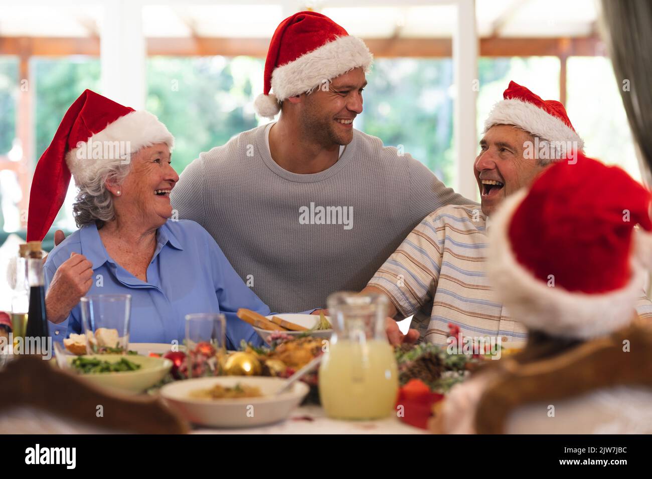 Senior caucasian couple and their adult son sitting at table for dinner together Stock Photo