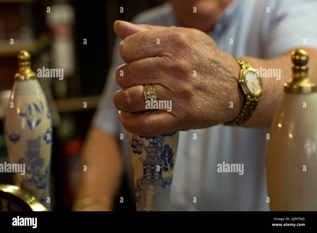 Close up of male hands pulling a pint at bar pump in an old english pub The Cockpit in the City of London , United Kingdom. Stock Photo