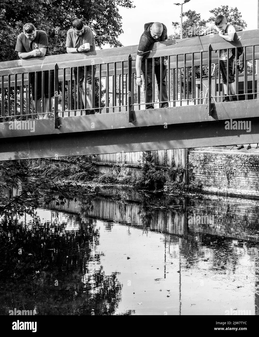 Fishing off a bridge, three men and a boy, River Thet, Thetford Stock Photo