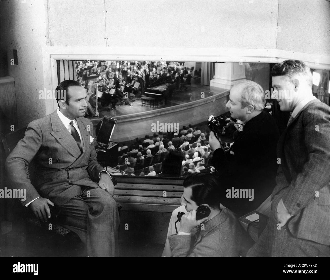 DOUGLAS FAIRBANKS Sr. visits Director HERBERT BRENON and Sound Recording Engineer CHARLES DAVID FORREST (on telephone) and Chief Recording Engineer HOWARD E. CAMPBELL in the Monitor Room of the world's largest talking motion picture stage at United Artists Studios in Hollywood to watch the filming of a 75 Piece Symphony Orchestra conducted by Dr. HUGO RIESENFELD in a concert scene for LUMMOX 1930 director HERBERT BRENON novel Fannie Hurst A Joseph M. Schenck Production (as Feature Productions) / United Artists Stock Photo