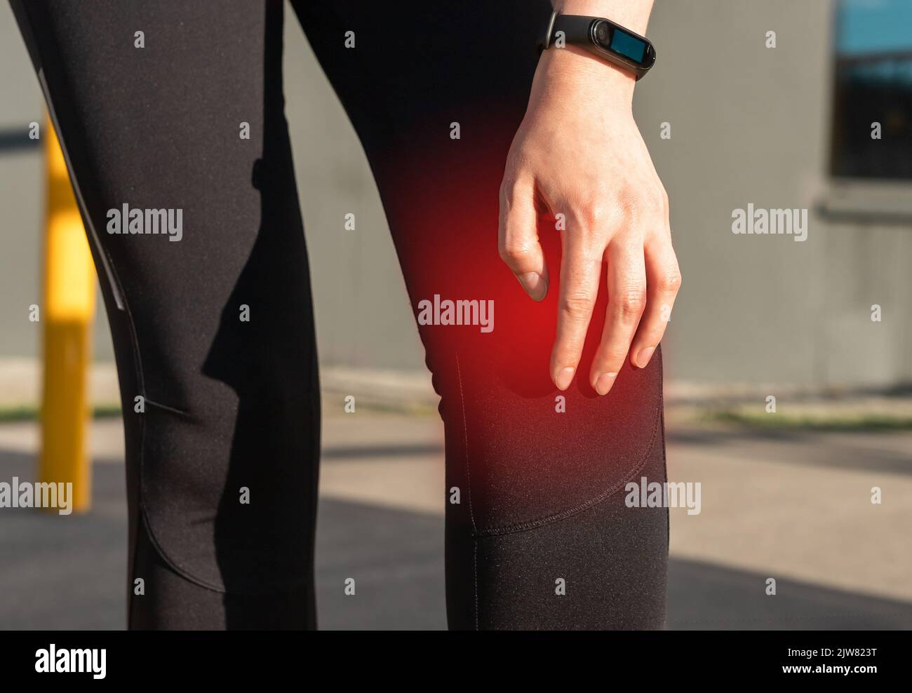 Knee pain, sports trauma concept. Woman holding painful kneecap with