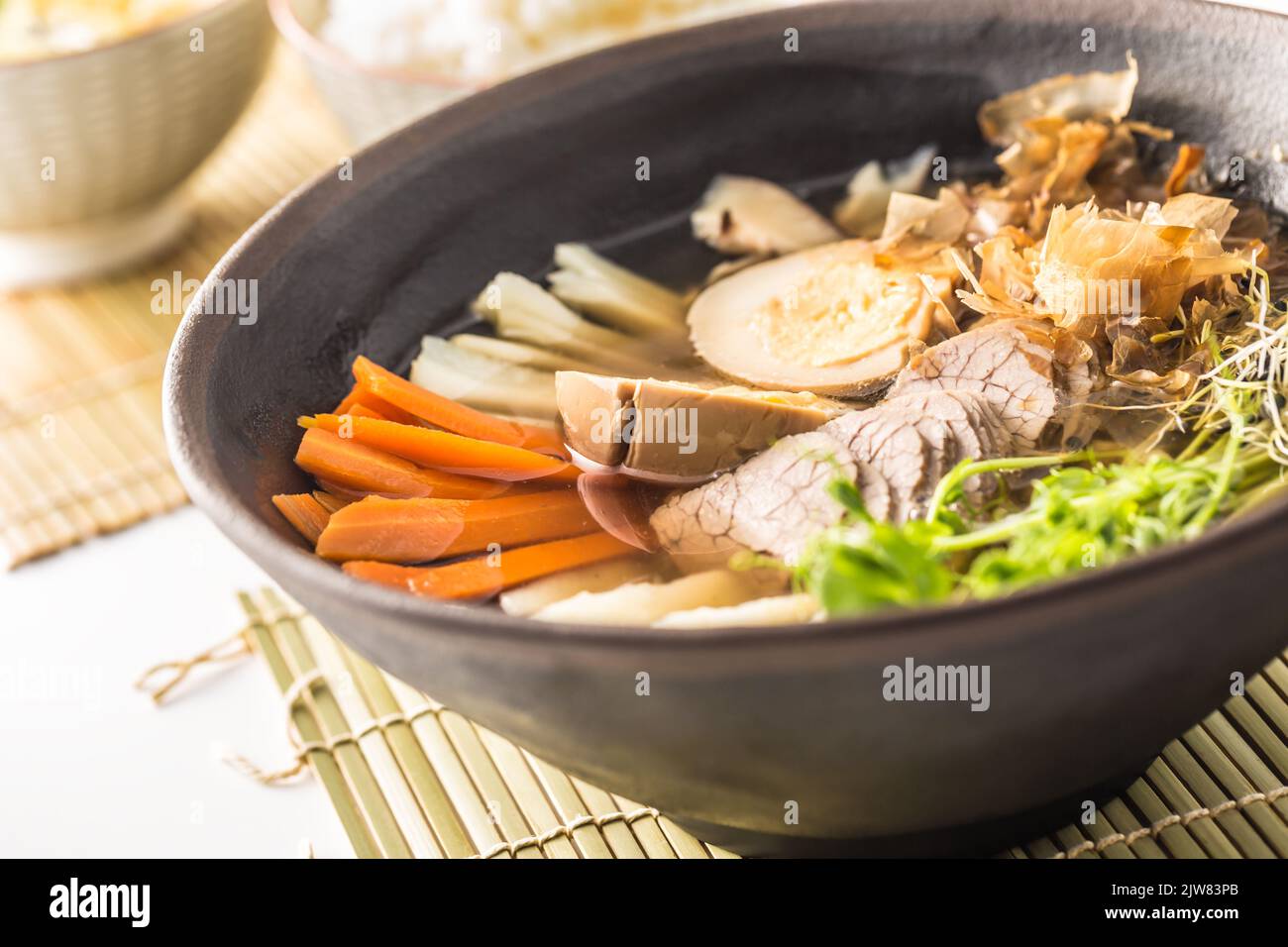 Japanese soup ramen with beef meat, egg and carrot on table in asian restaurant. Stock Photo