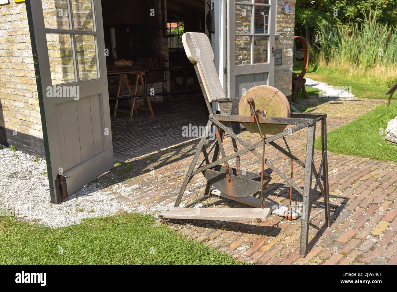 Oudeschild, Netherlands. August 2022. An old grinding stone for scissors and knives. High quality photo Stock Photo