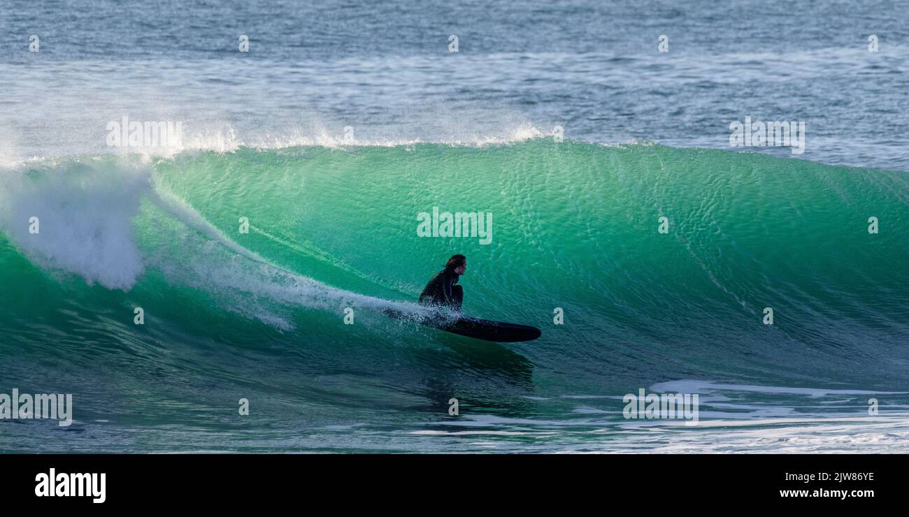 Surfer enjoying the amazing barrelling waves on Porthleven reefs ...