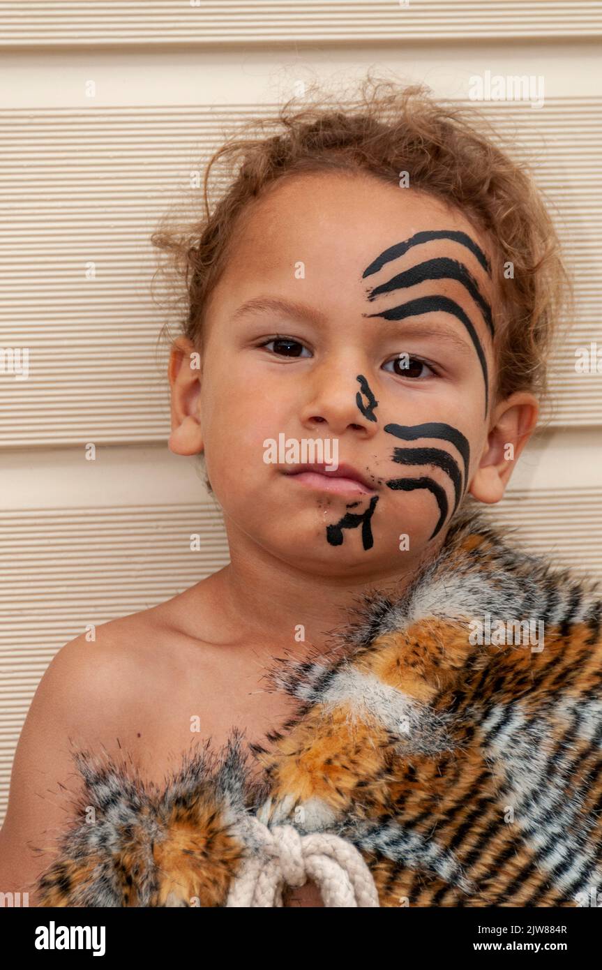 A Maori child dressed in his traditional dance dress at his parent’s