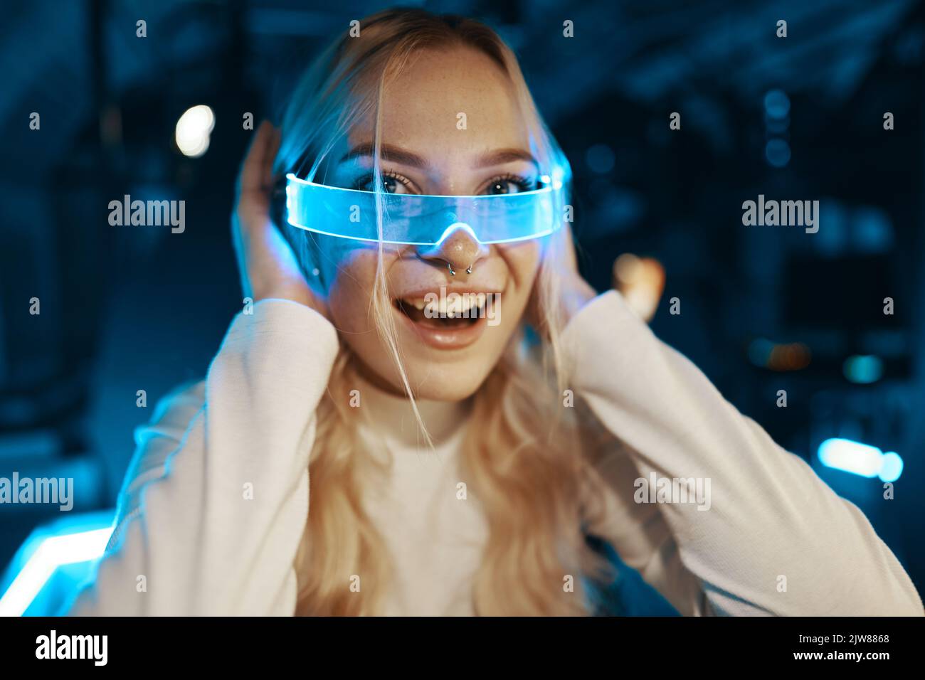 Cute blonde in futuristic fashion style. Neon glasses for a young woman ...