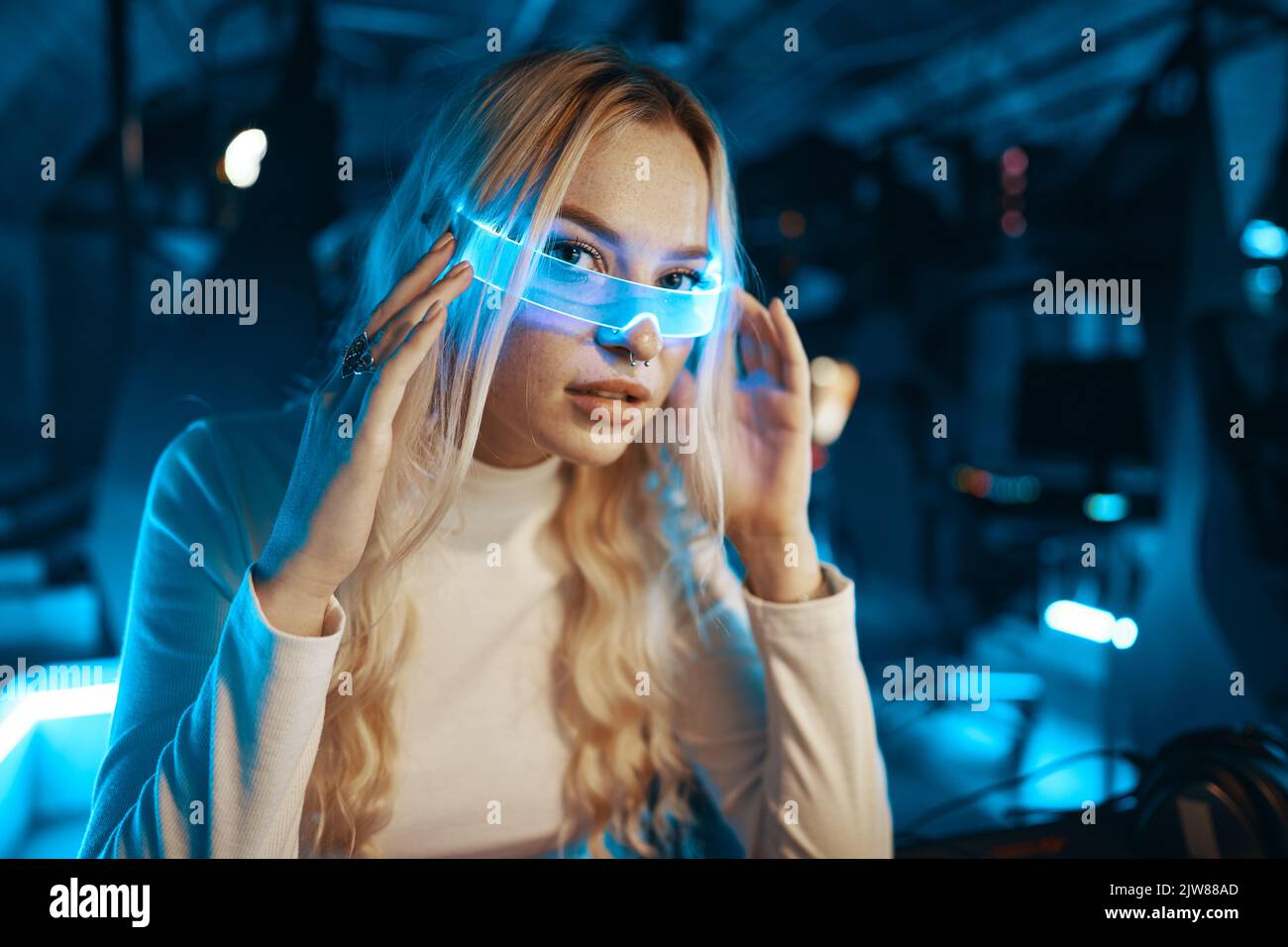 Cute blonde in futuristic fashion style. Neon glasses for a young woman ...