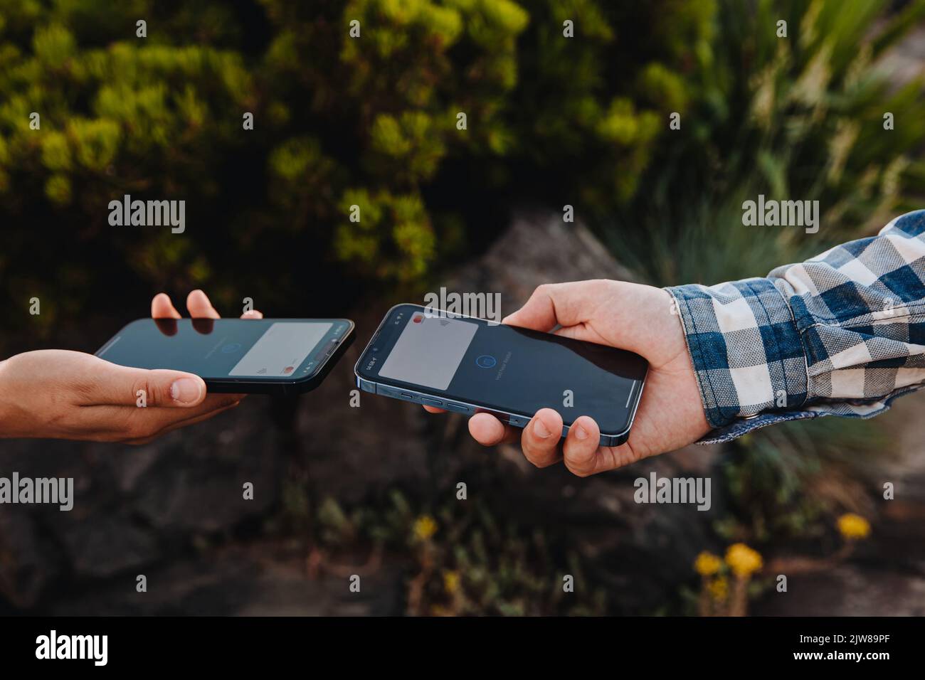 Horishni Plavni, Ukraine - 07, Juny 2022 : Tap to pay. Man and woman using iPhone as a payment terminal, contactless payment concept Stock Photo