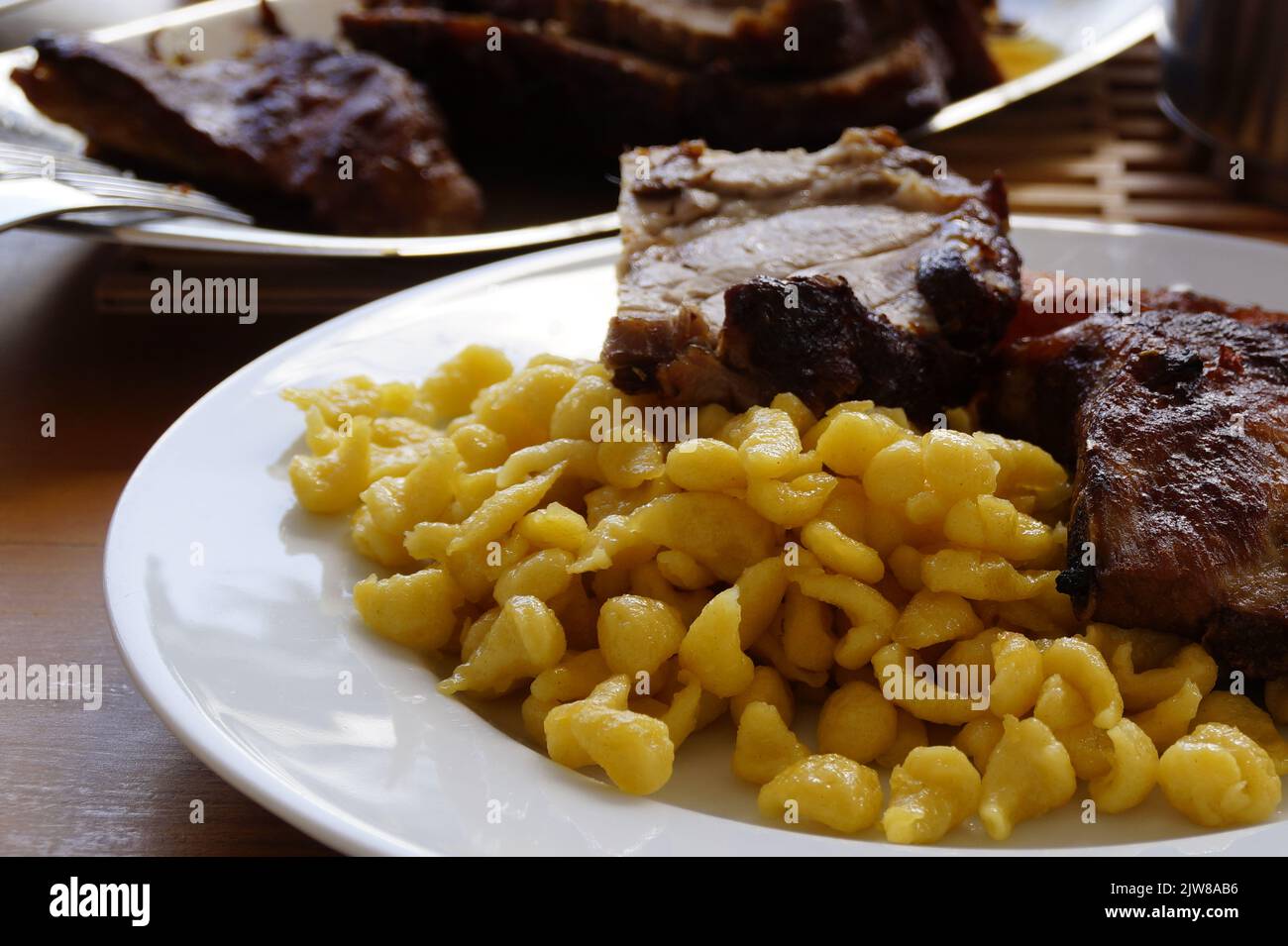 a Swabian meal of spaetzle or spaetzli with fried spareribs, Munich, Bavaria, Germany Stock Photo