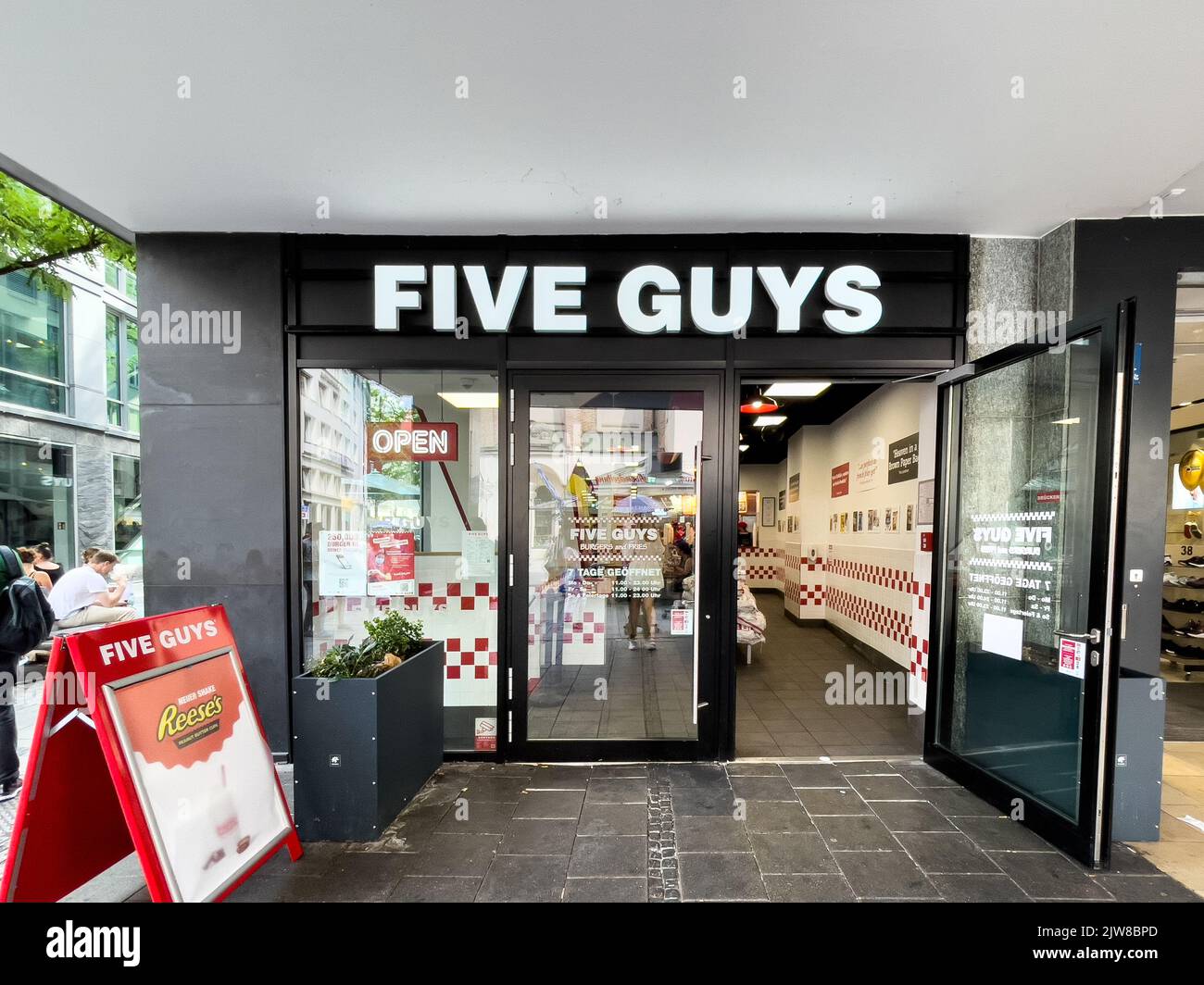 Five Guys sign at a Five Guys Fast food restaurant in Munich town center Stock Photo