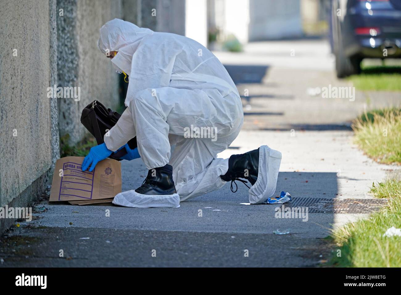 Forensic officers remove a bag at the scene in the Rossfield Estate in