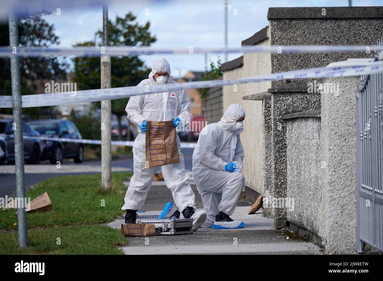 Forensic officers remove items from the scene in the Rossfield Estate