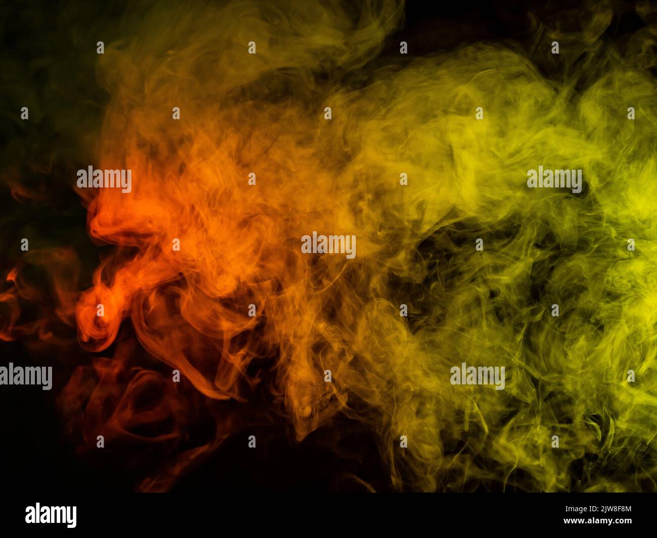 Red-yellow smoke spreads on a black background Stock Photo - Alamy
