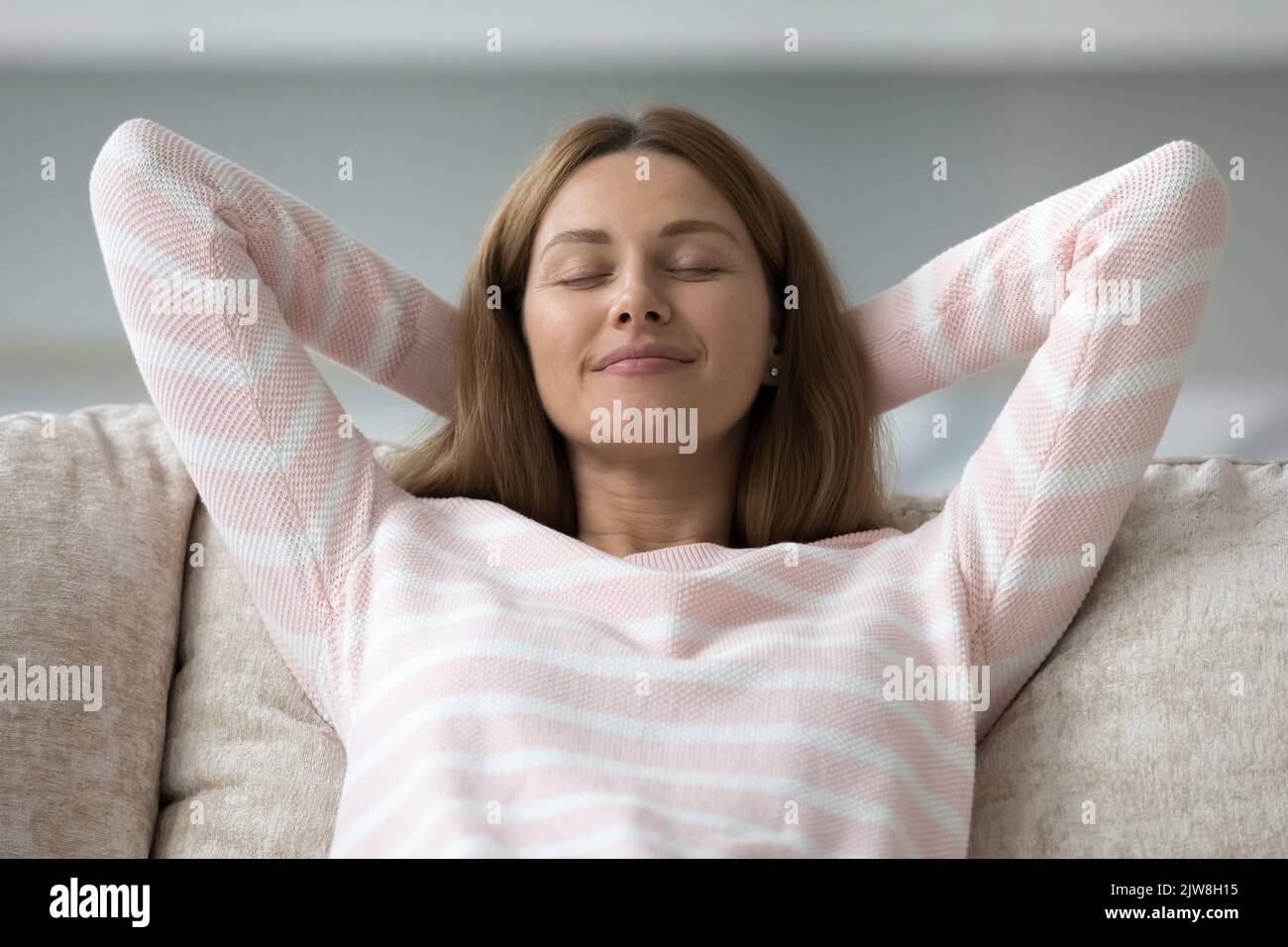 Peaceful happy pretty 30s woman relaxing on couch Stock Photo