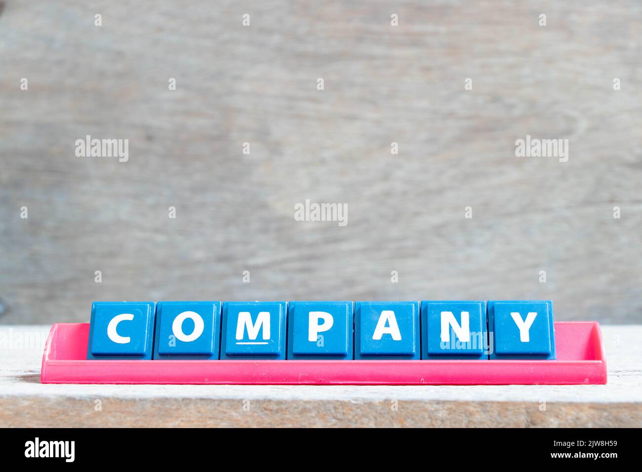 Tile alphabet letter with word company in red color rack on wood ...
