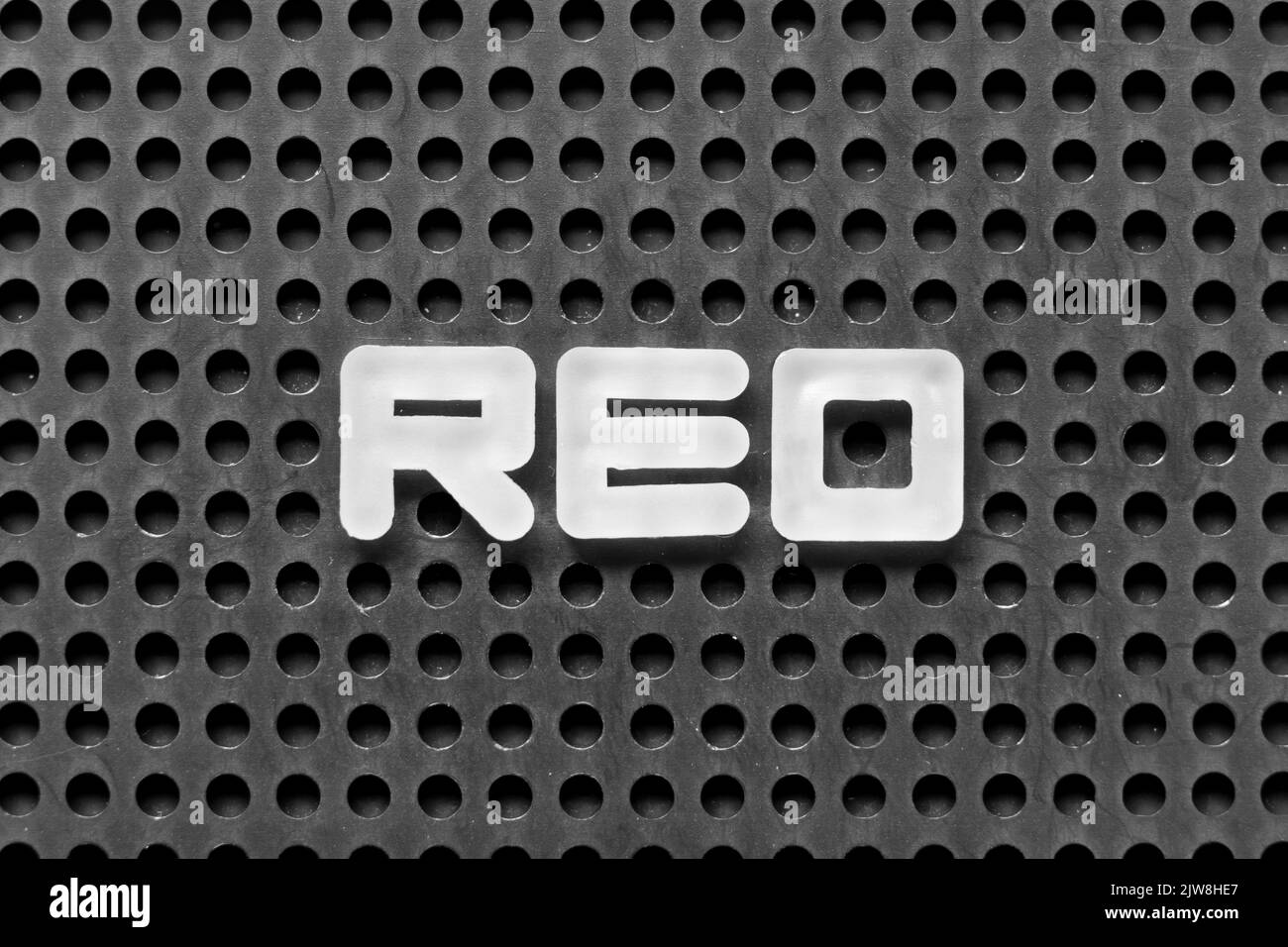 White alphabet letter in word REO (Abbreviation of Real estate owned) on black pegboard background Stock Photo