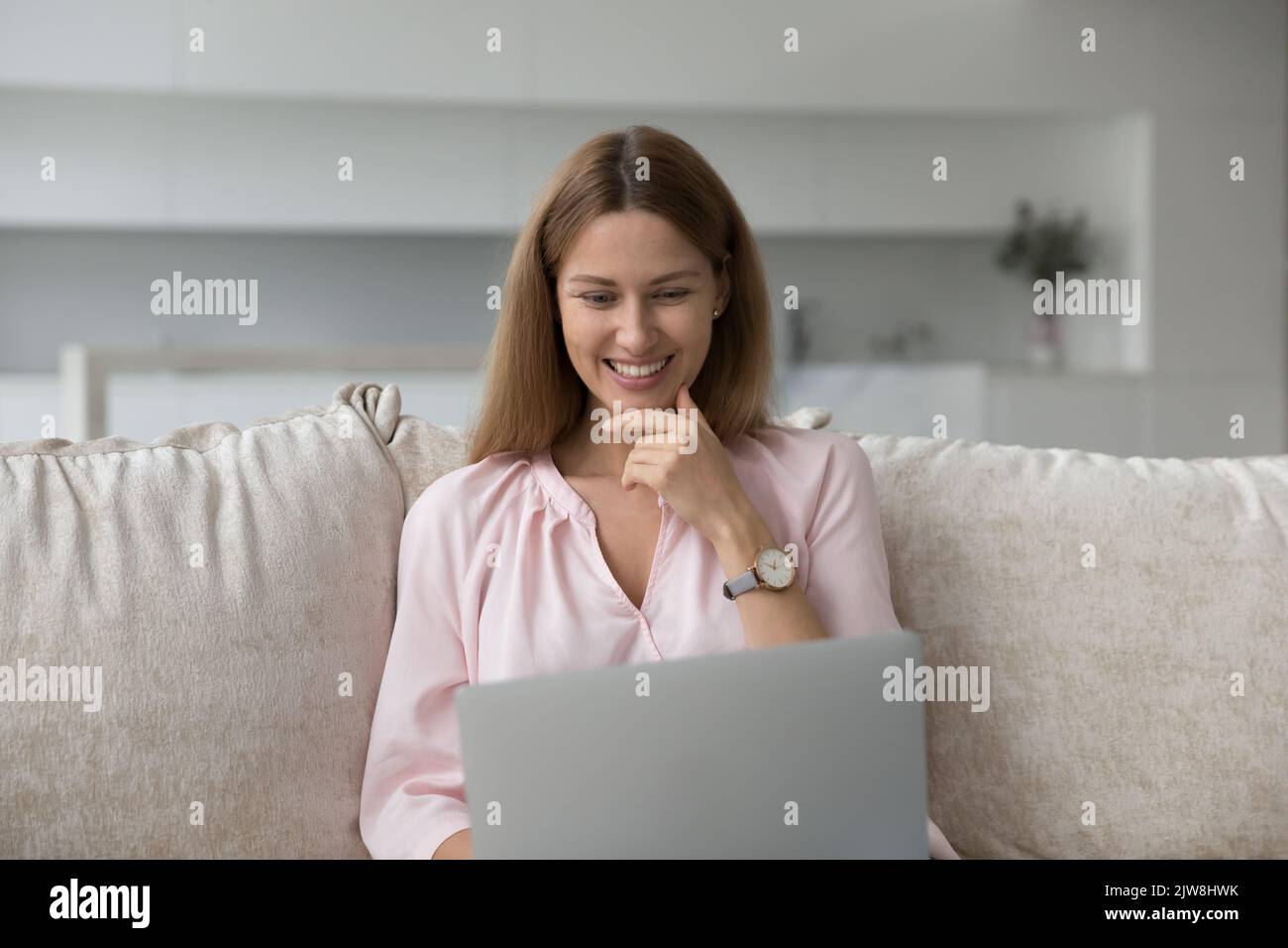 Happy pretty young woman using laptop at home Stock Photo