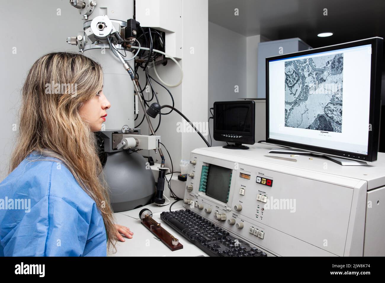 Young female scientist working at the laboratory with an electron microscope Stock Photo