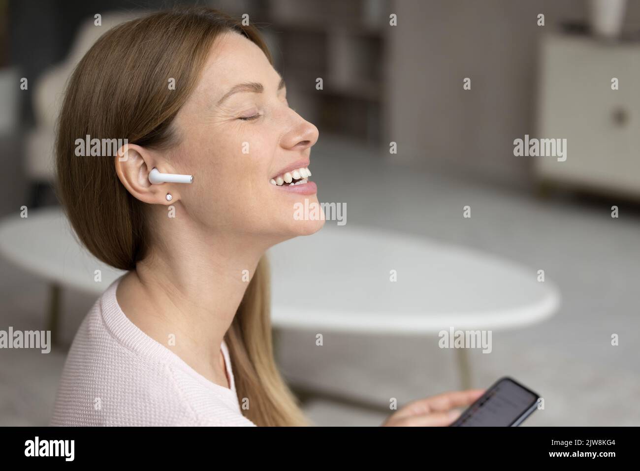 Happy excited millennial woman listening to inspiring music Stock Photo