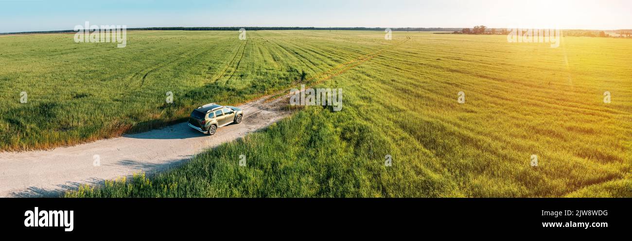 Aerial view of Renault Duster car SUV parked near countryside road in field rural landscape. Aerial view of car SUV parked near countryside road on a Stock Photo
