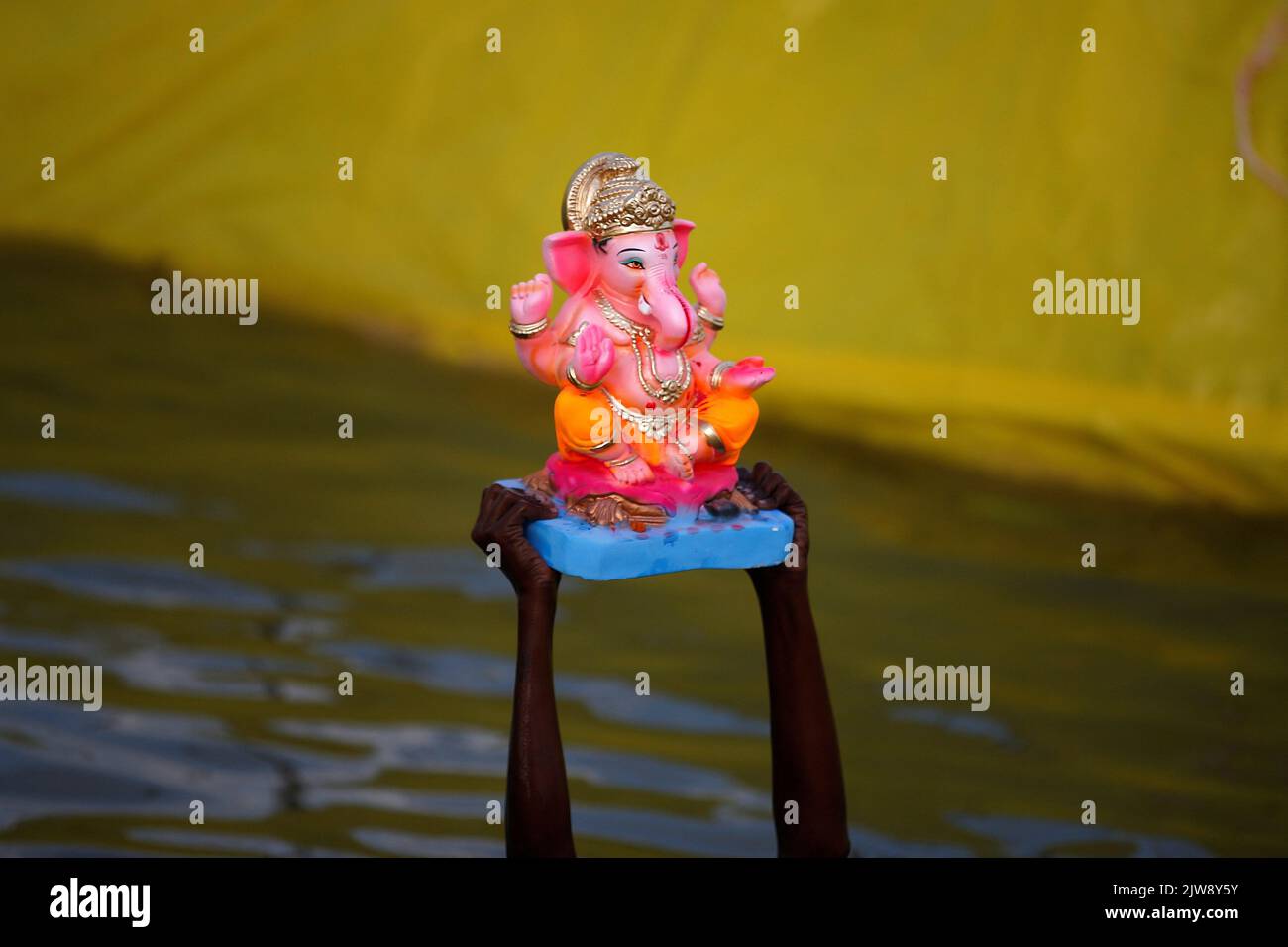 A boy carries an idol of the Hindu god Ganesh, the deity of prosperity, to be immersed in an artificial pond during the Ganesh Chaturthi festival in Ahmedabad, India, September 4, 2022. REUTERS/Amit Dave     TPX IMAGES OF THE DAY Stock Photo