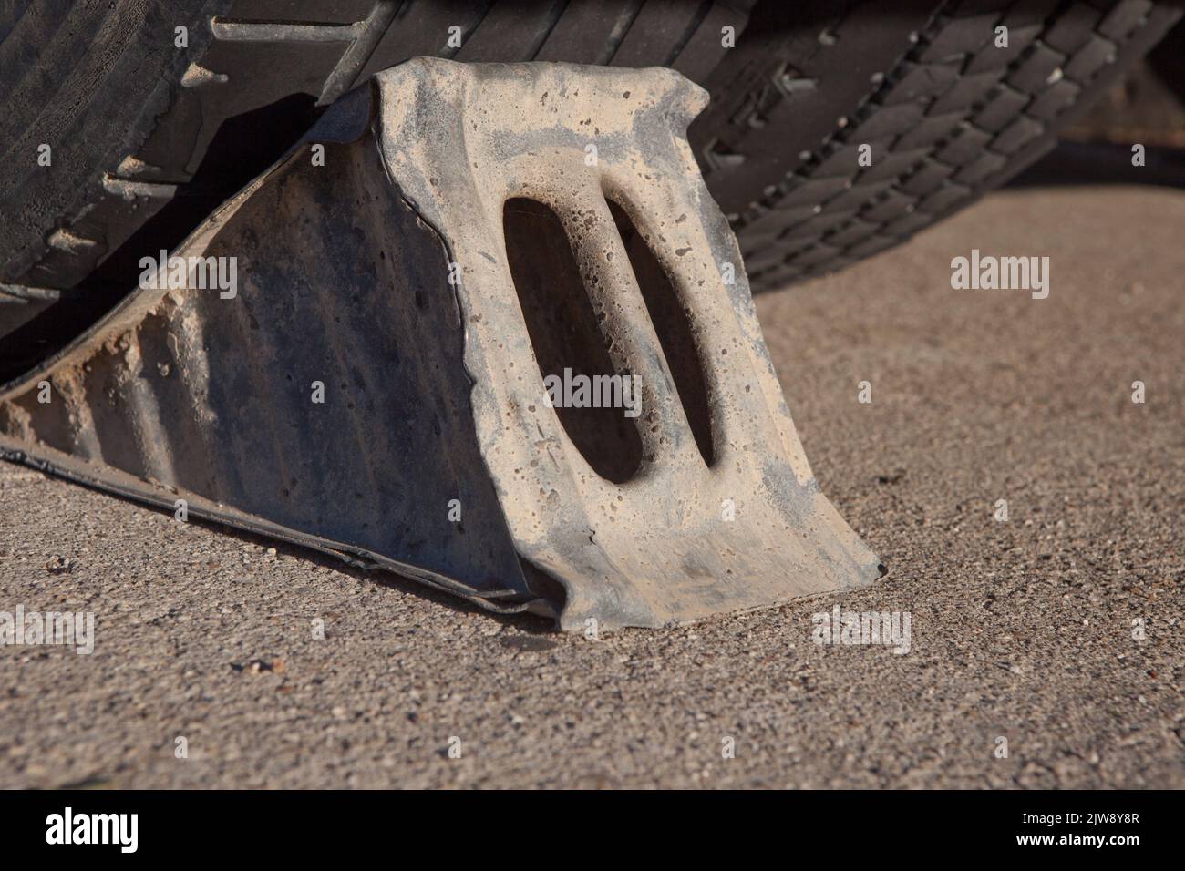 Full metal wheel chock under trailer. Ground view Stock Photo