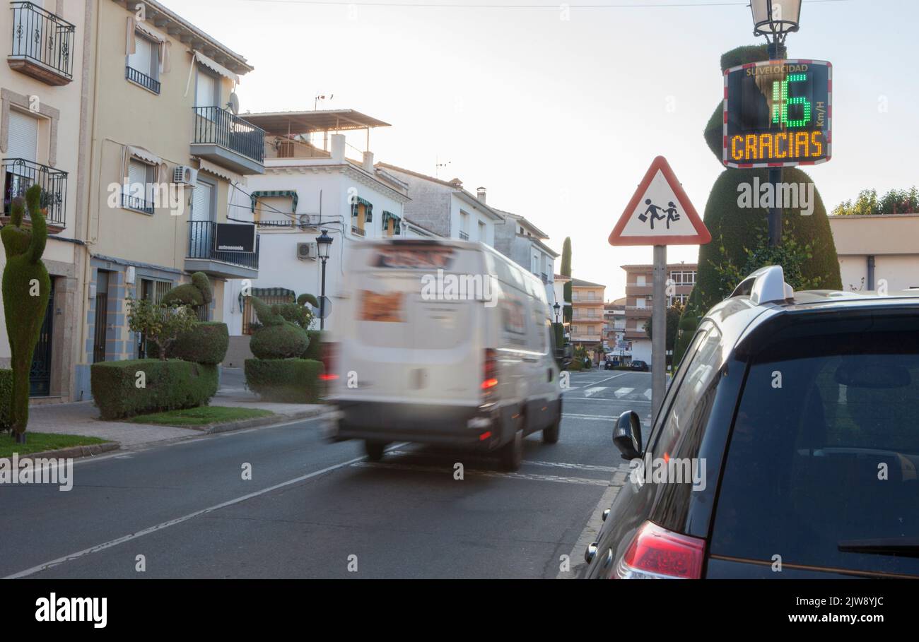 Vehicule crossing close to radar speed sign pole. Low motion shot Stock Photo