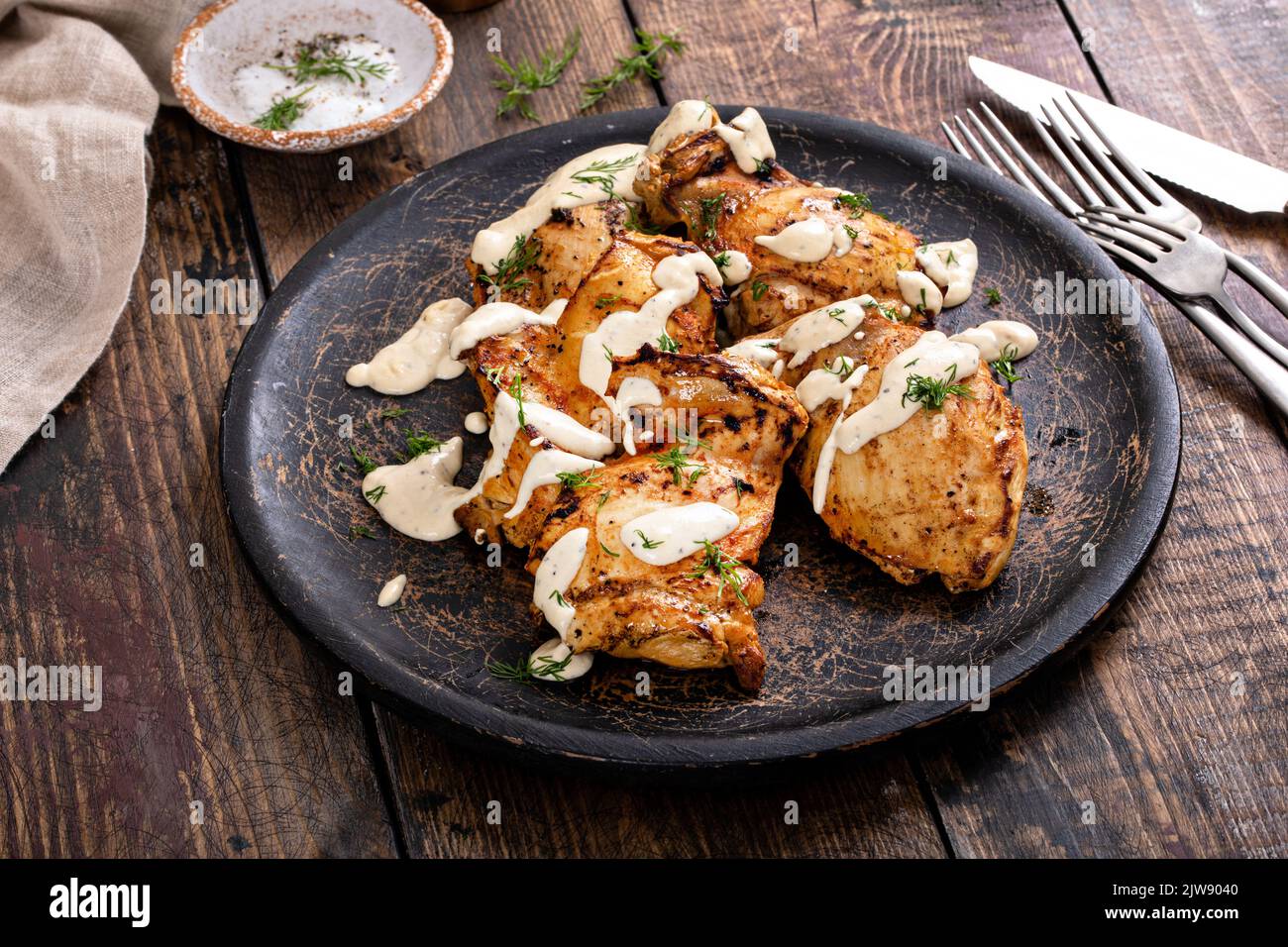 Roasted chicken thighs with dill pickle sauce Stock Photo