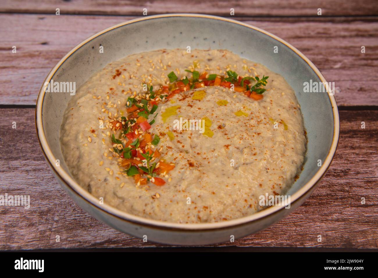 Traditional arabian eggplant dip baba ganoush with herbs and smoked paprika on a wooden background Stock Photo