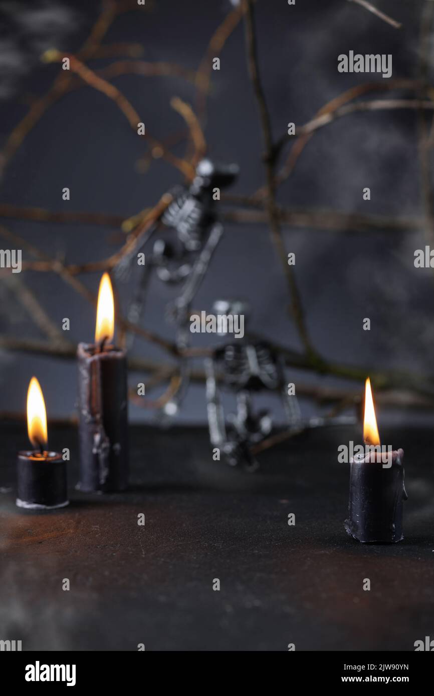 Halloween background with candles and skeletons in darkness. Spooky