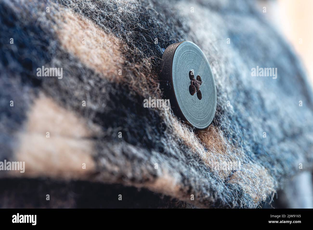 Button on a warm blue shirt, macro shot. Stock Photo