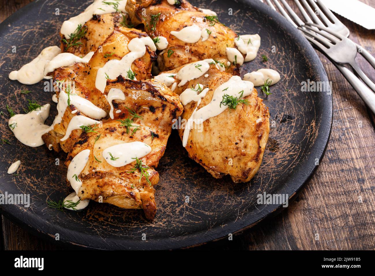Roasted chicken thighs with dill pickle sauce Stock Photo