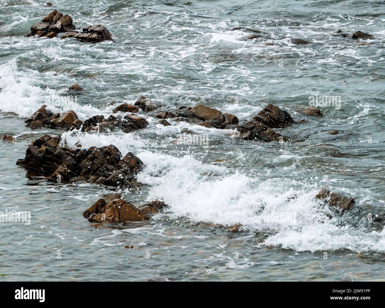 Waves coming over the rocks at Cullen Bay, Cullen, Moray, Morayshire, Scotland, UK Stock Photo